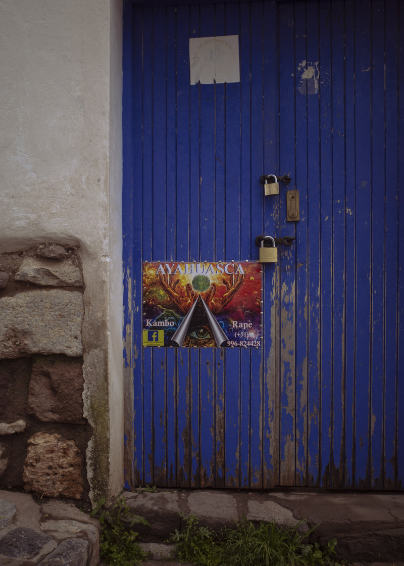 Puerta de tablas azules con candados y un cartel de colores.